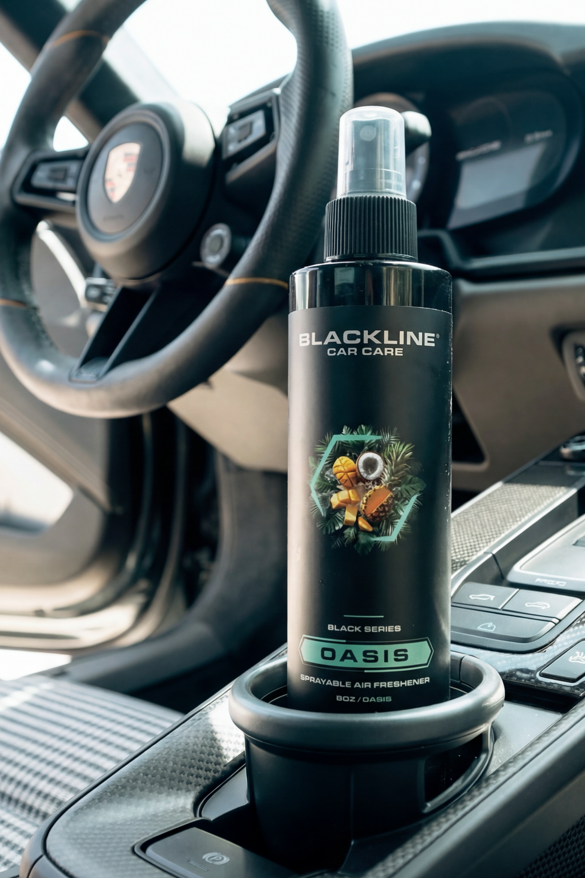 Blackline Oasis air freshener bottle resting in a vehicle cup holder.