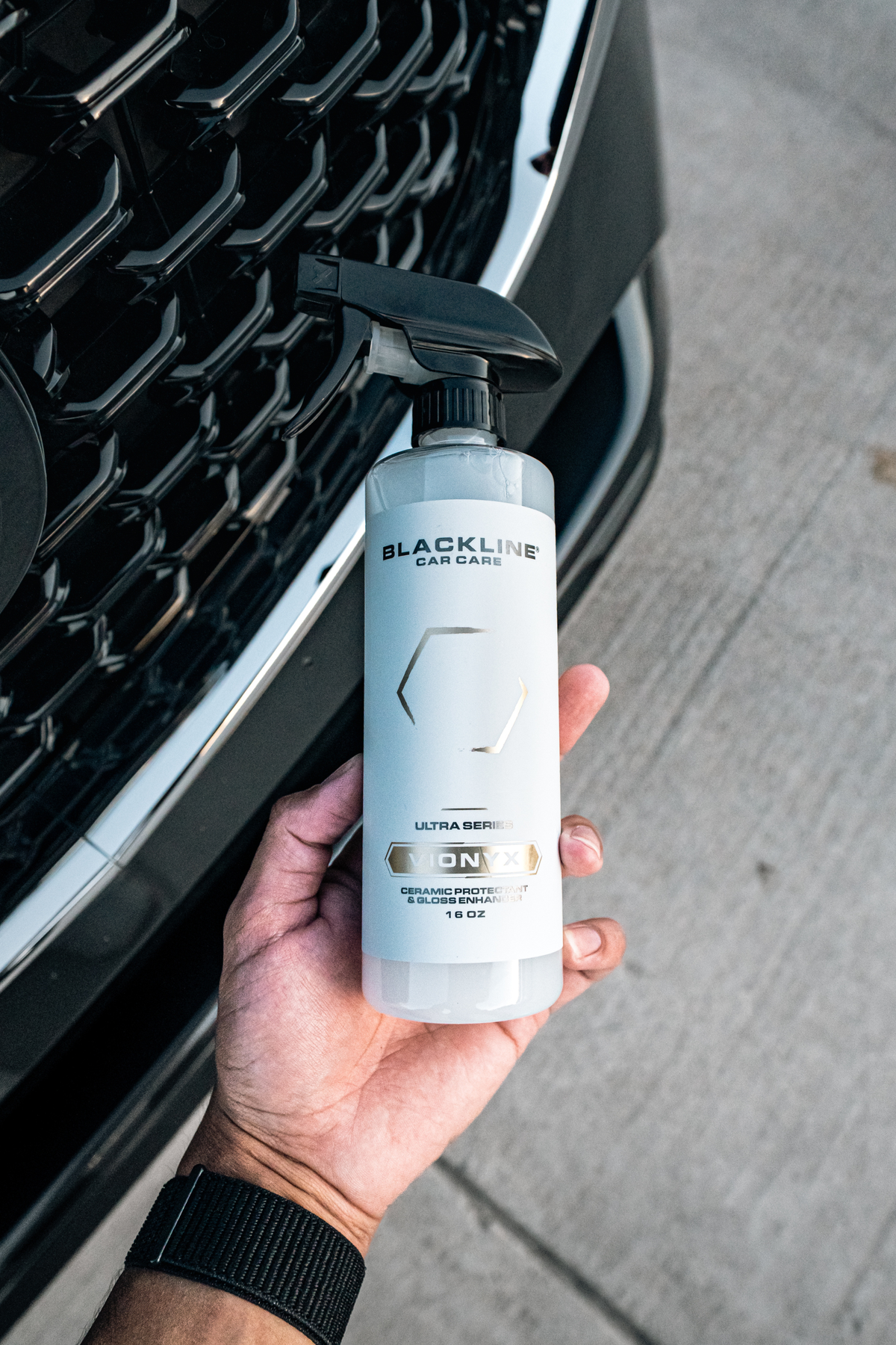 Hand applying Blackline Vionyx ceramic spray to a vehicle panel.