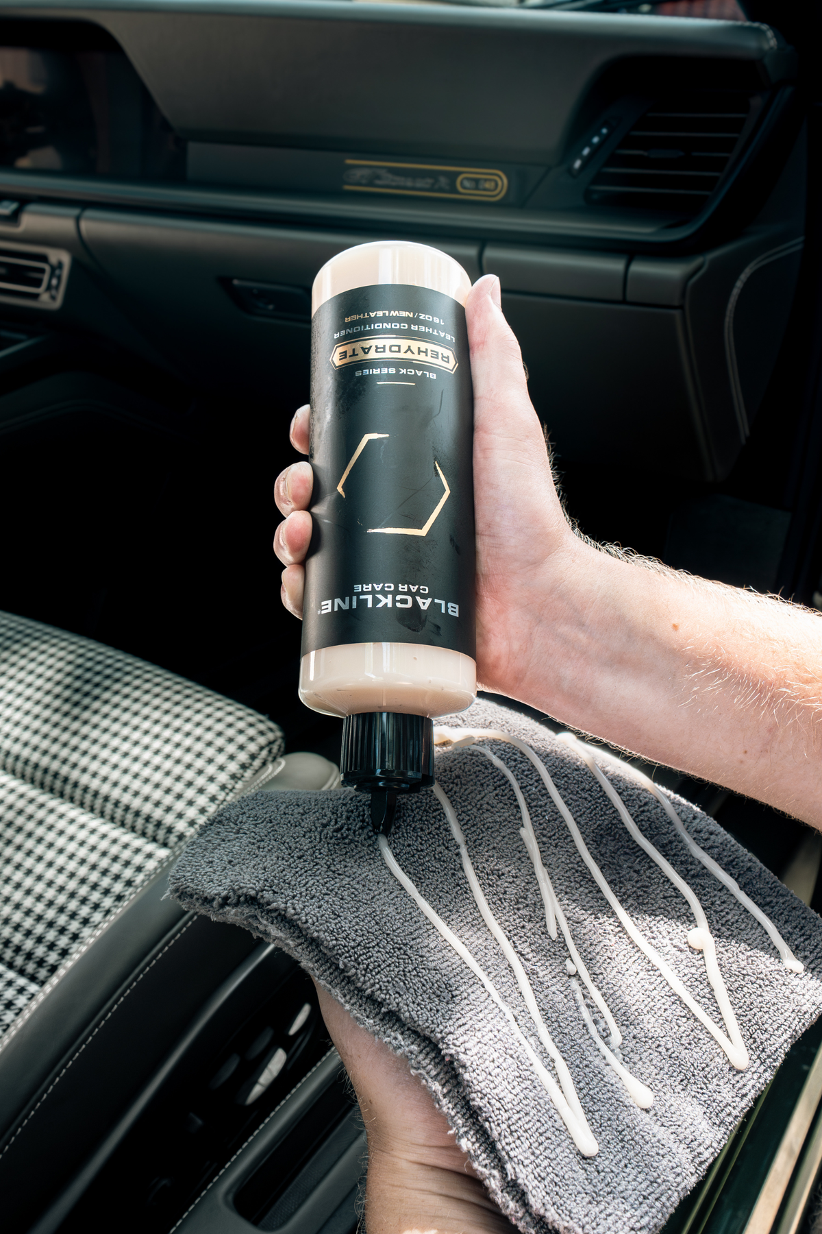 Black-gloved hand applying Blackline Gentle APC during interior detailing.