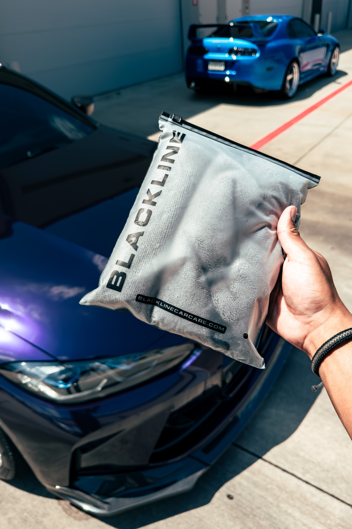 Hand applying Waterless Wash from the kit to a vehicle panel.