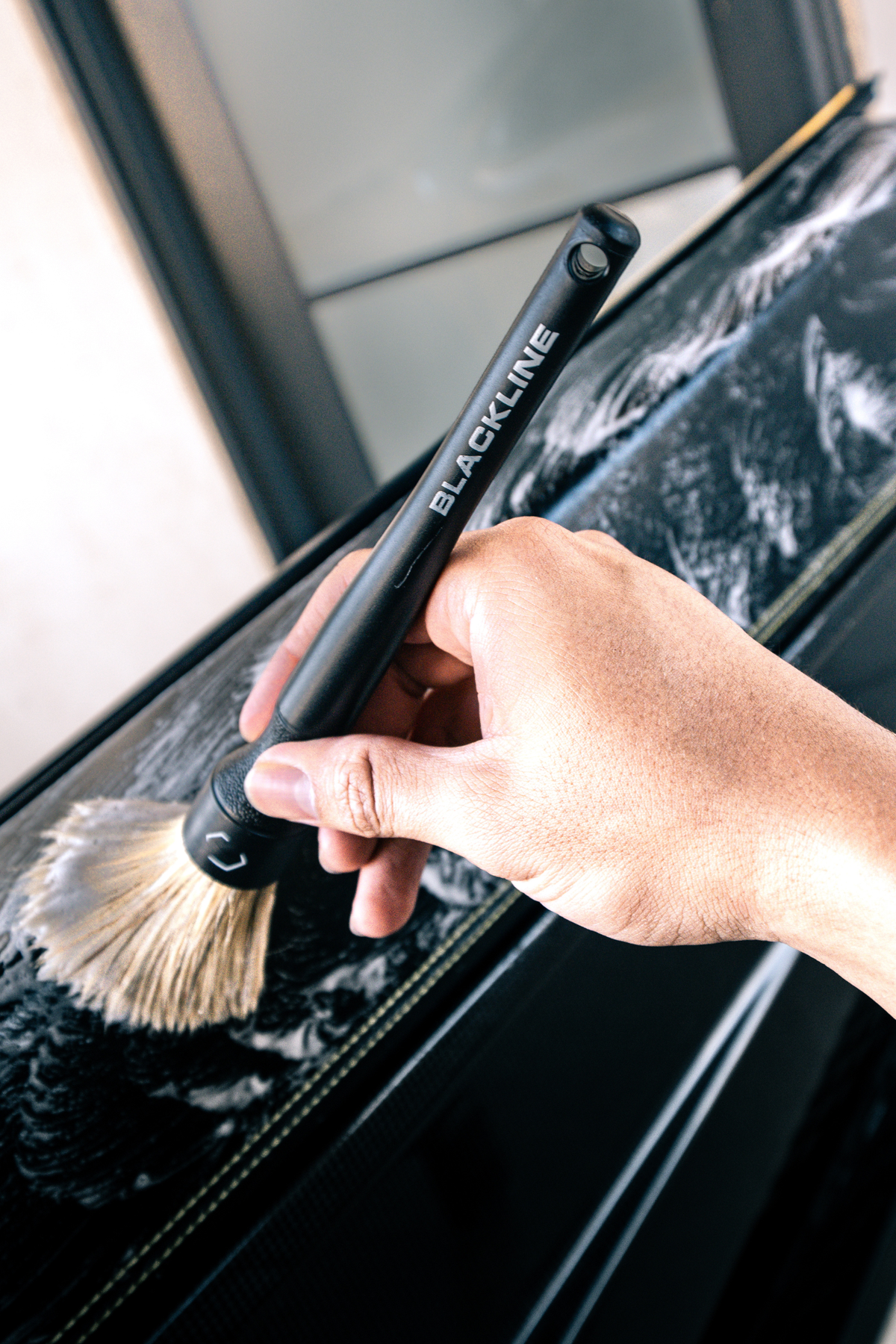 Boar's-hair brush from the Blackline set being used on a vehicle interior.