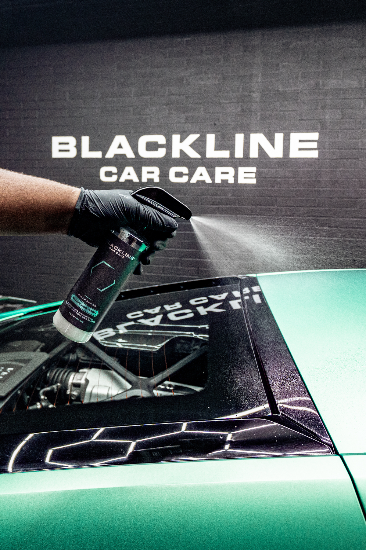 Microfiber towel wiping vehicle surface with Waterless Wash applied.