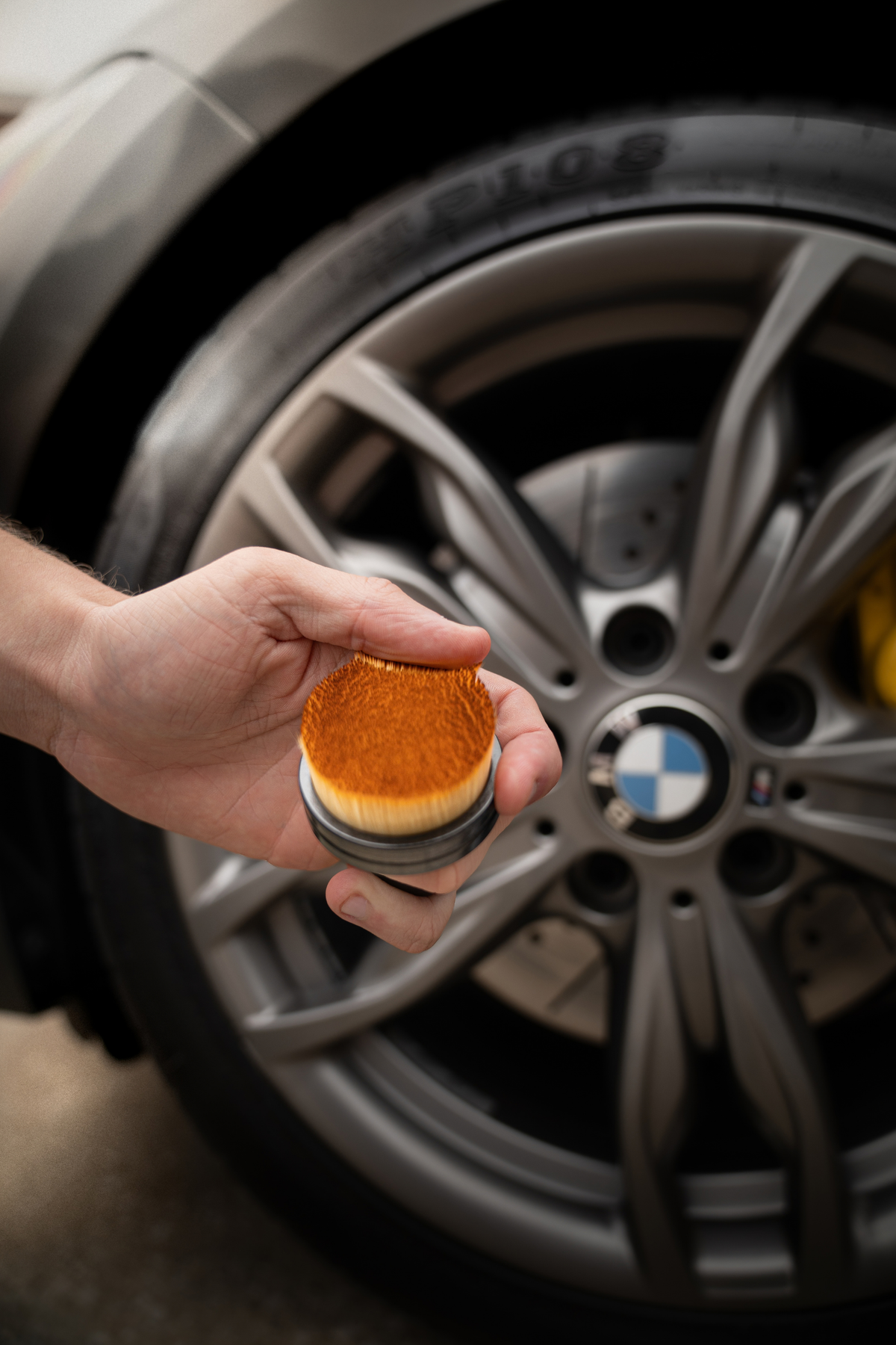 Blackline Tire Shine Applicator Brush in use applying tire dressing to a black tire sidewall