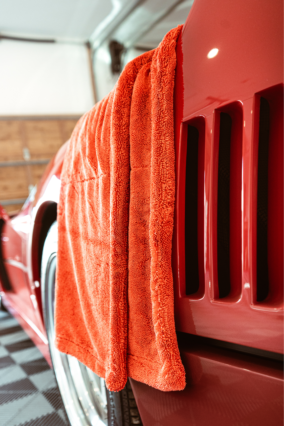 Red drying towel draped over a red Ferrari F40 fender.
