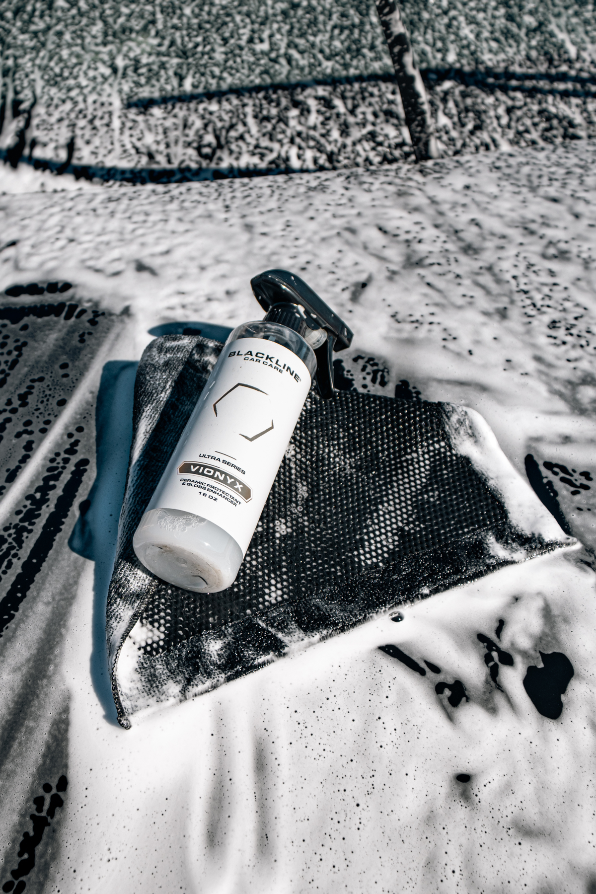 Lifestyle photo of Blackline Vionyx ceramic spray in a detailing setting.